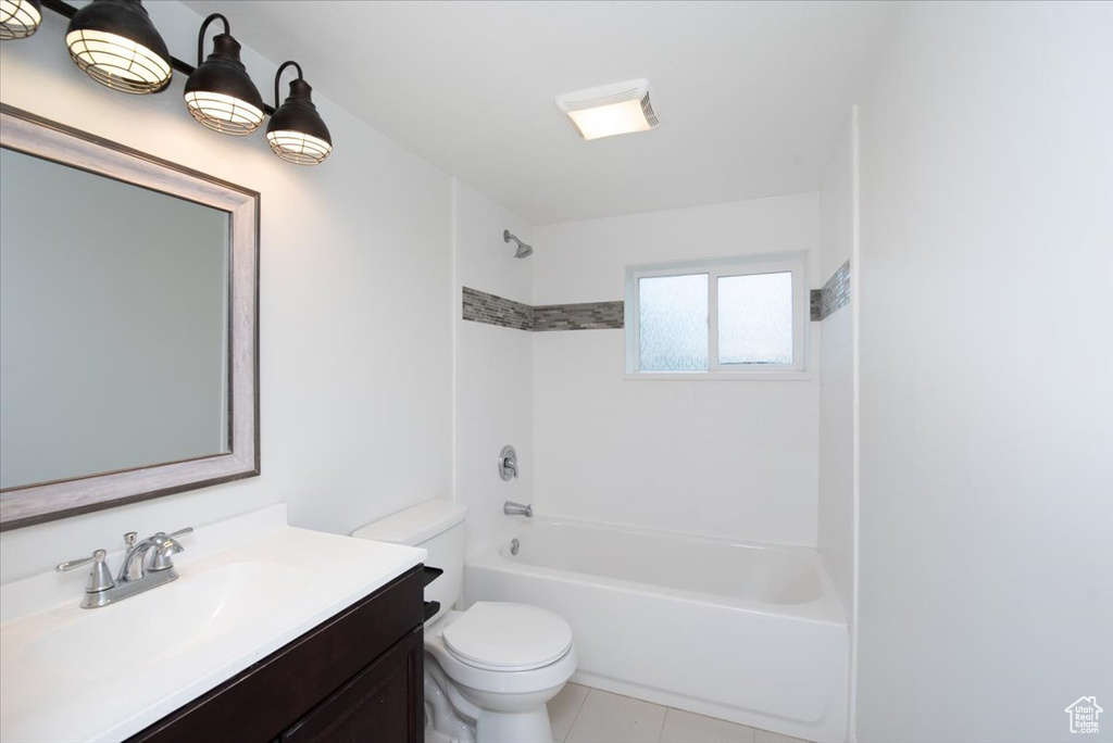 Bathroom with vanity, washtub / shower combination, tile patterned floors, and toilet