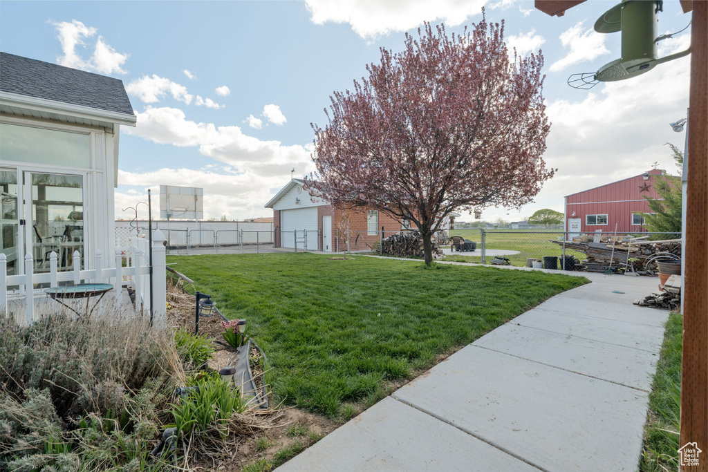 View of yard featuring fence and a garage