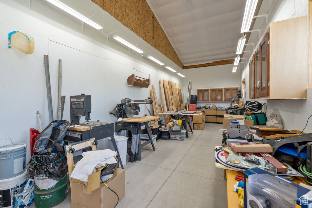 Interior space featuring concrete flooring, lofted ceiling, and a workshop area