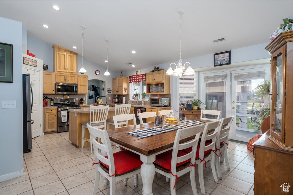 Dining area with visible vents, a toaster, a chandelier, and light tile patterned floors