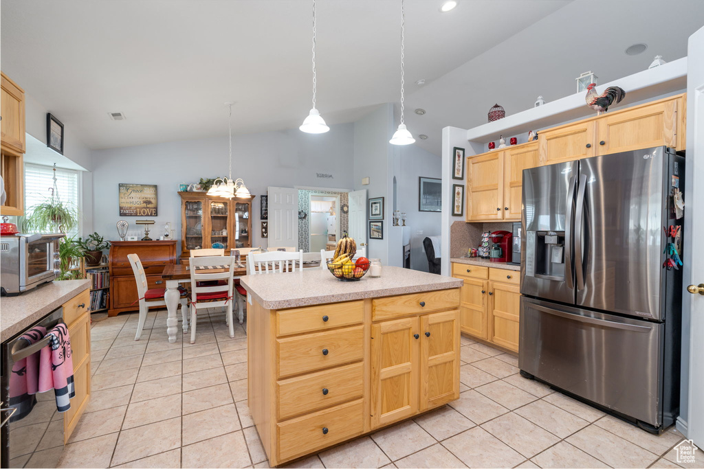 Kitchen with light countertops, light brown cabinetry, light tile patterned floors, and stainless steel fridge with ice dispenser