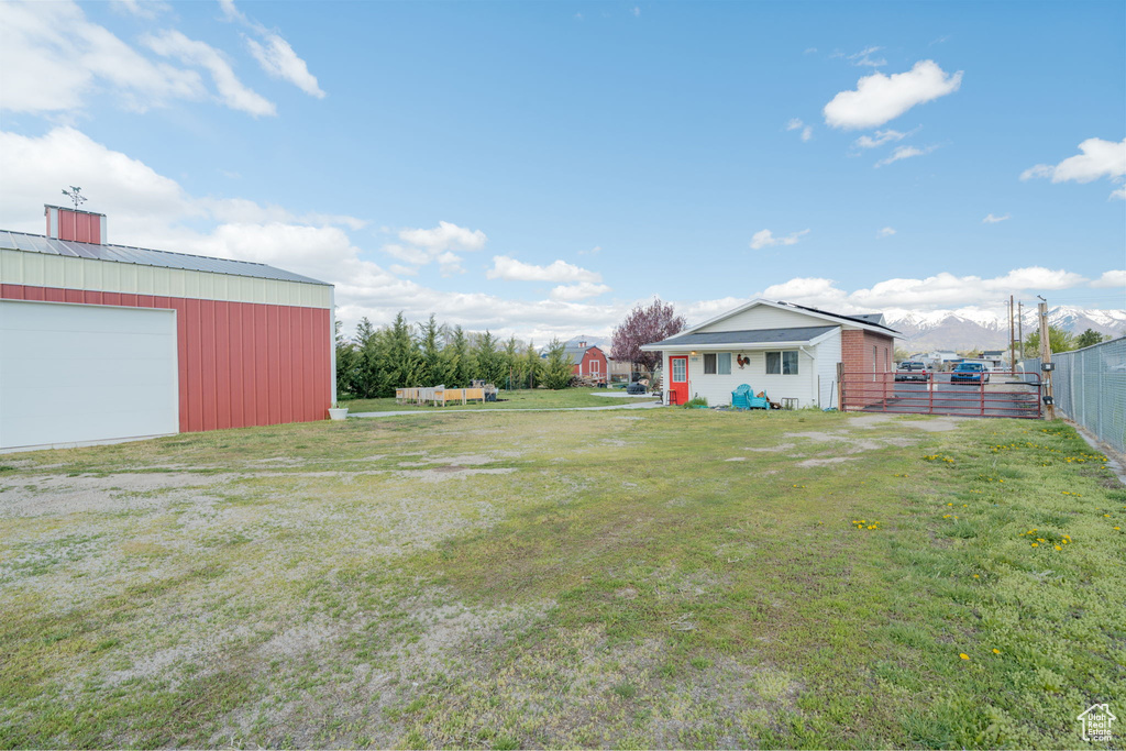 View of yard featuring an outdoor structure, fence, and a detached garage