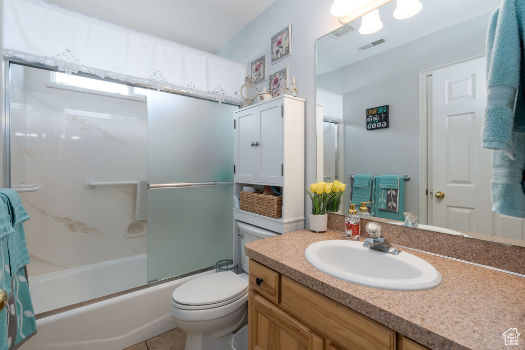 Bathroom featuring visible vents, toilet, enclosed tub / shower combo, and vanity