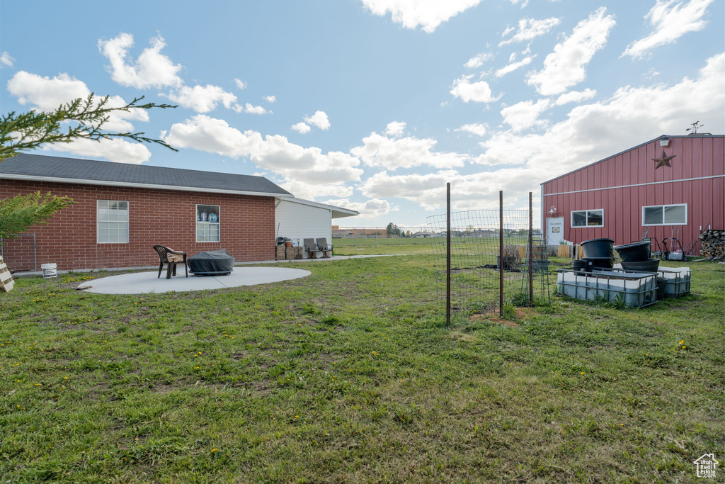 View of yard with fence and a patio