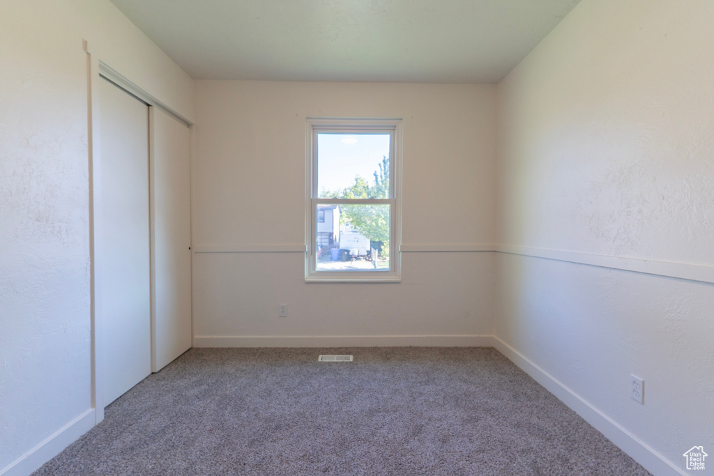 Unfurnished bedroom with a closet, visible vents, carpet, and baseboards