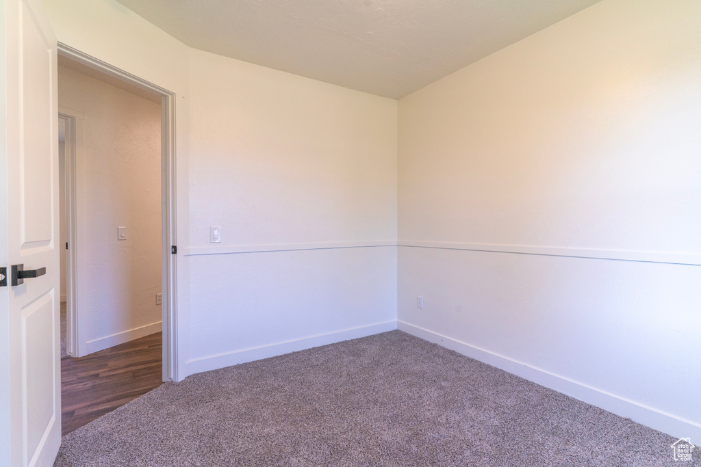 Carpeted spare room featuring baseboards