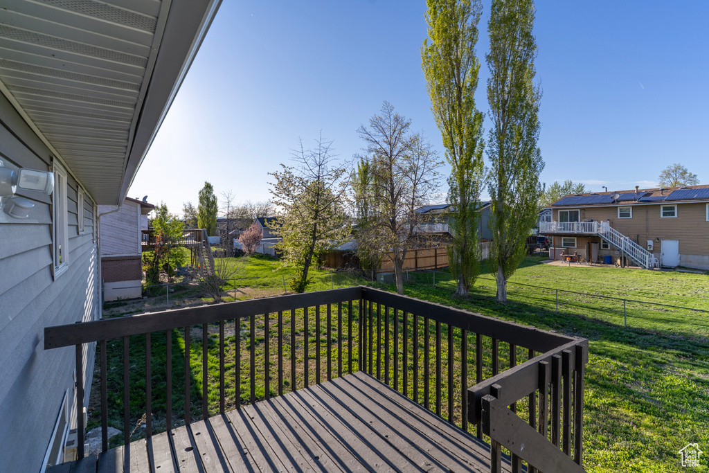 Deck with a residential view, a lawn, and fence