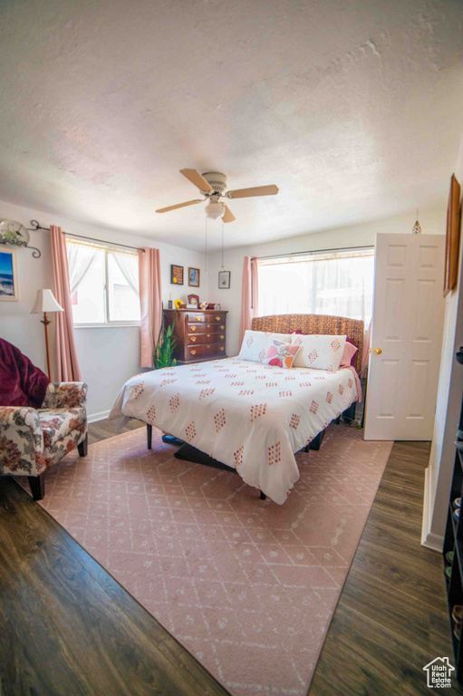 Bedroom with a textured ceiling, ceiling fan, and wood finished floors
