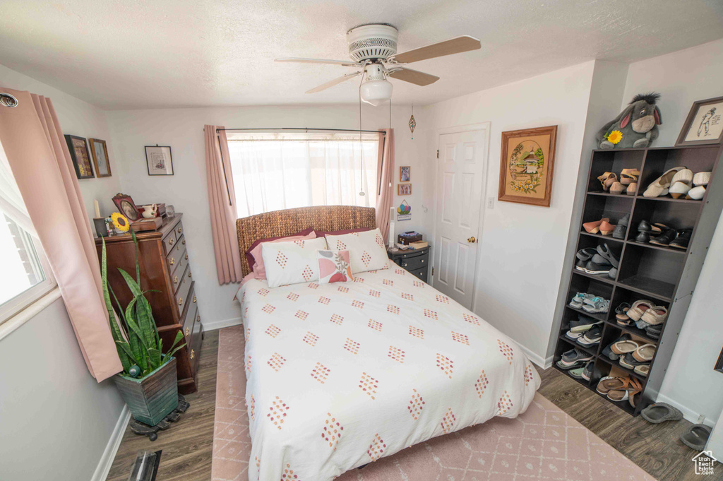 Bedroom with a ceiling fan, baseboards, and wood finished floors