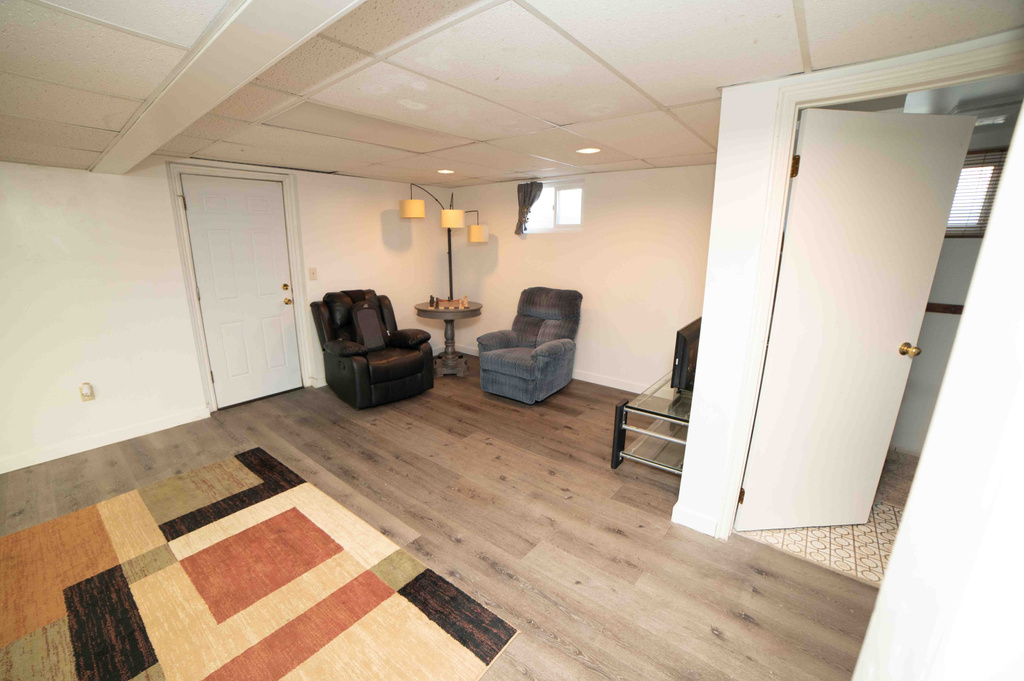 Sitting room featuring baseboards, recessed lighting, wood finished floors, and a paneled ceiling