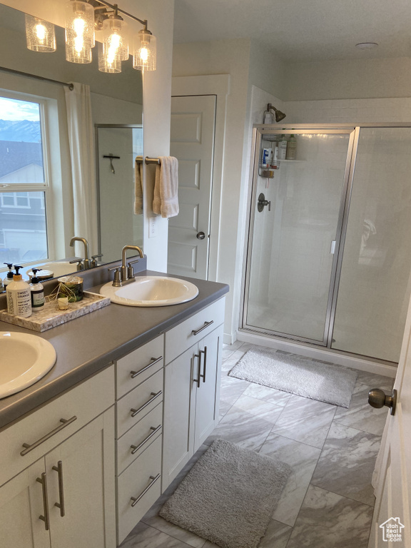 Bathroom featuring a stall shower and a sink