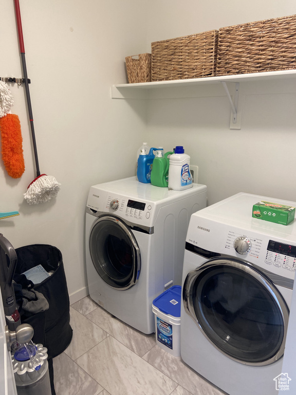 Laundry room featuring independent washer and dryer, marble finish floor, baseboards, and laundry area