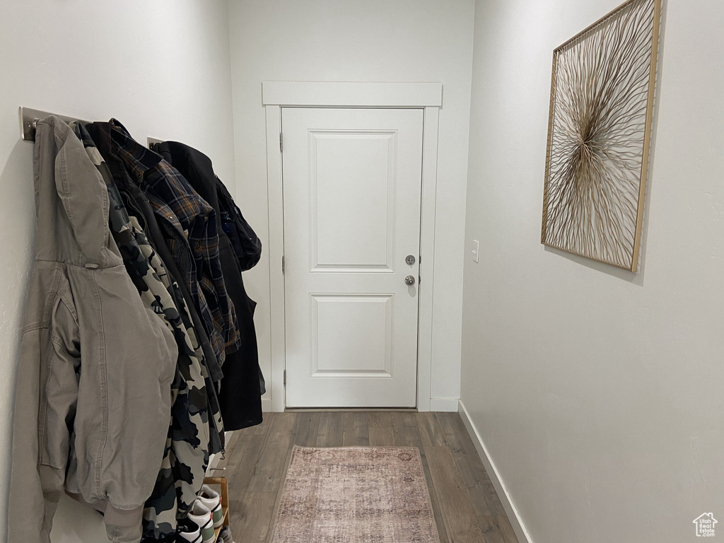 Doorway to outside with baseboards and wood finished floors