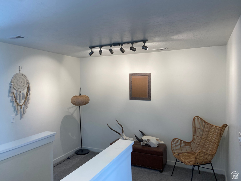 Sitting room with visible vents, baseboards, and light colored carpet
