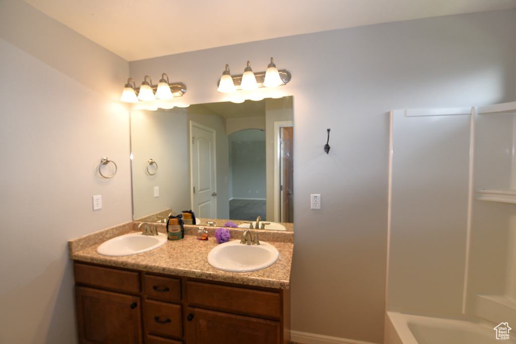 Full bathroom featuring double vanity and shower / bath combination