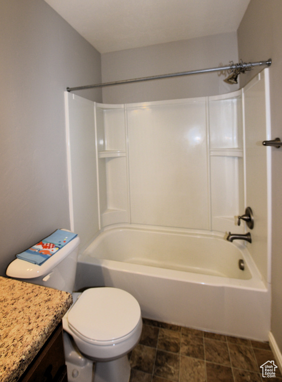 Bathroom featuring vanity,  shower combination, and stone finish floors