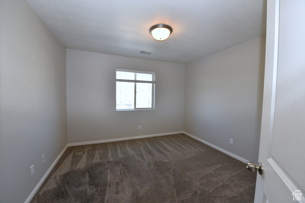 Carpeted empty room featuring baseboards