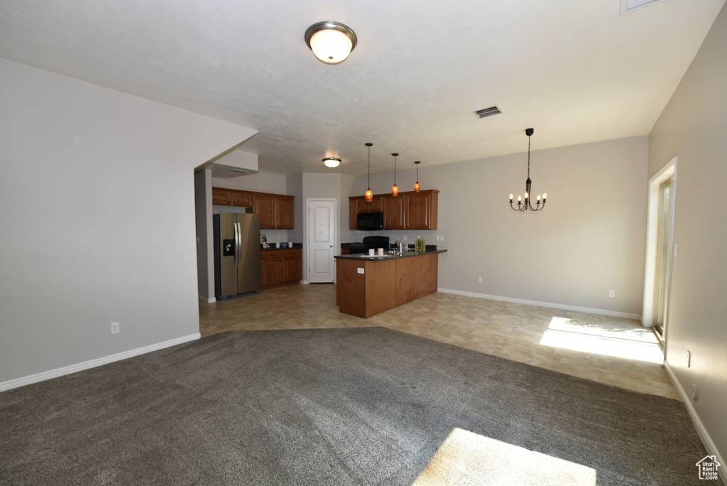 Unfurnished living room with a chandelier and light colored carpet