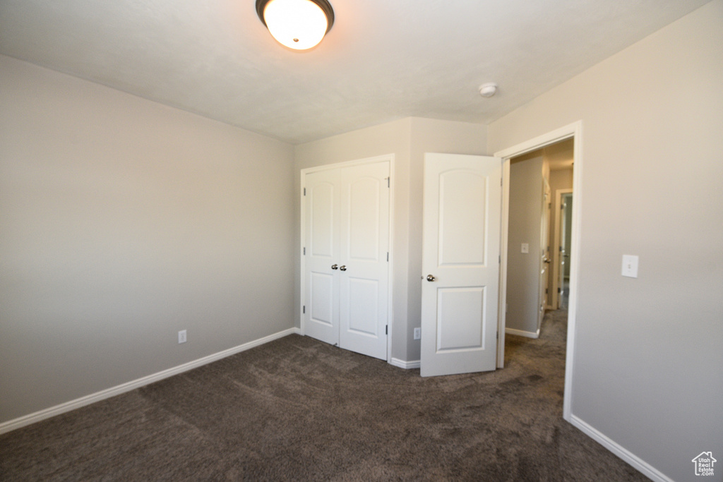 Unfurnished bedroom with carpet and a closet