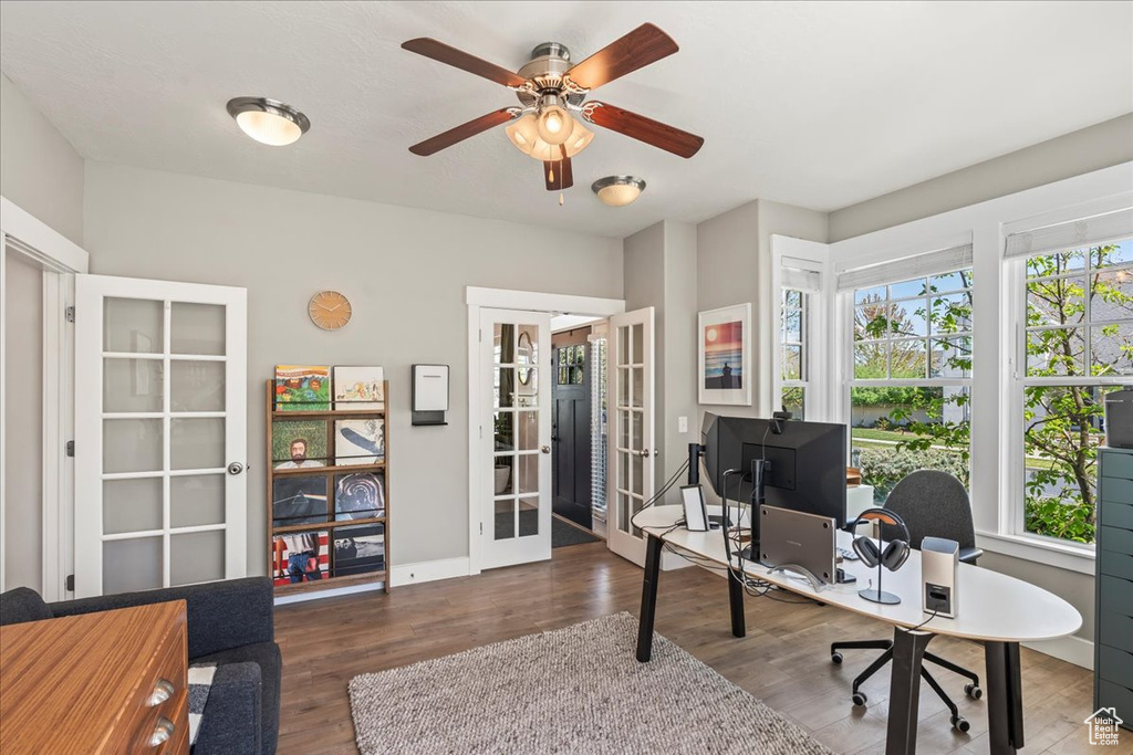 Office area with wood finished floors, a ceiling fan, and french doors