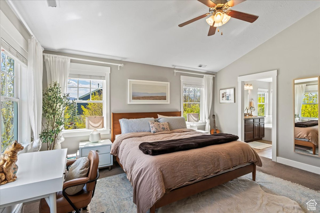 Bedroom featuring vaulted ceiling, visible vents, a ceiling fan, carpet floors, and ensuite bathroom