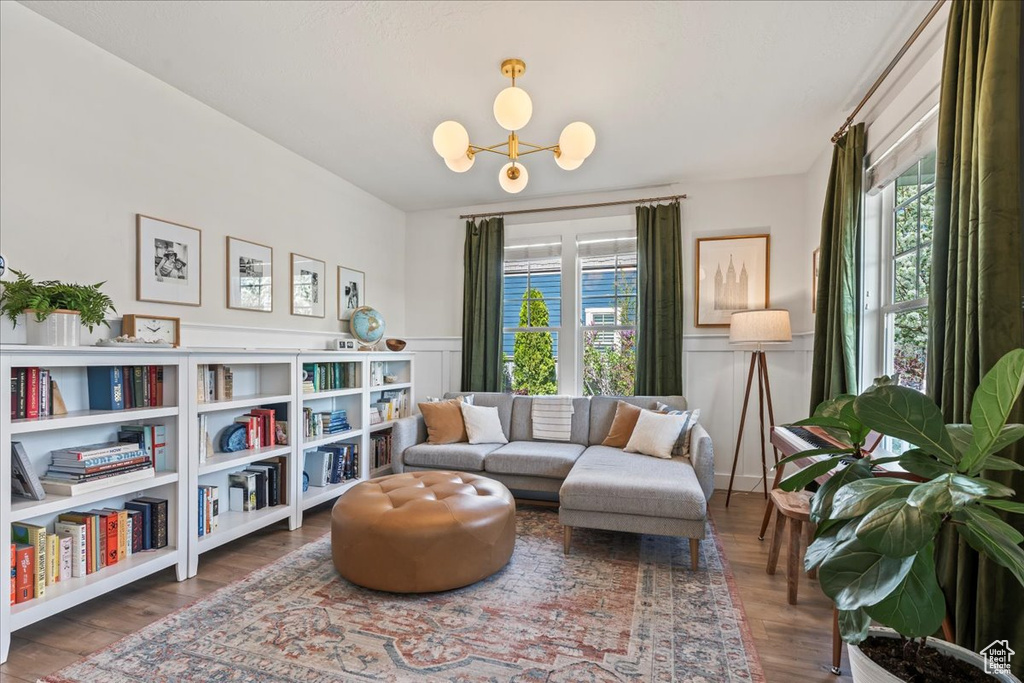 Sitting room featuring wainscoting, a notable chandelier, and wood finished floors