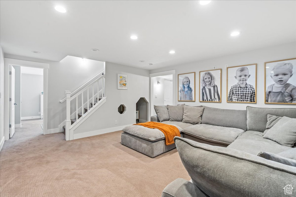 Living room featuring light colored carpet, baseboards, stairs, and recessed lighting