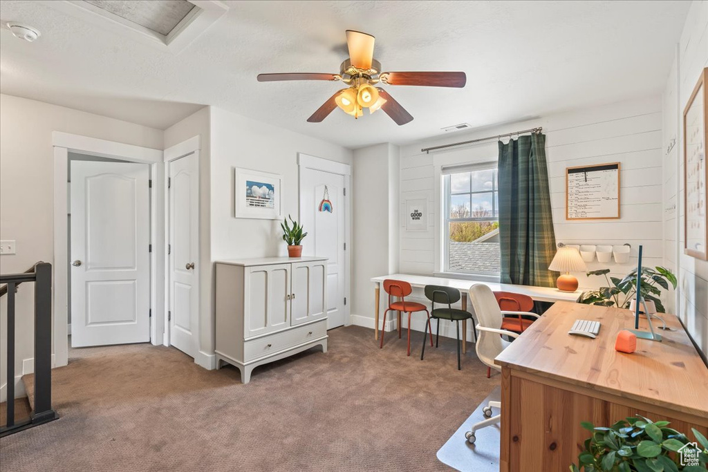 Carpeted home office featuring visible vents and ceiling fan