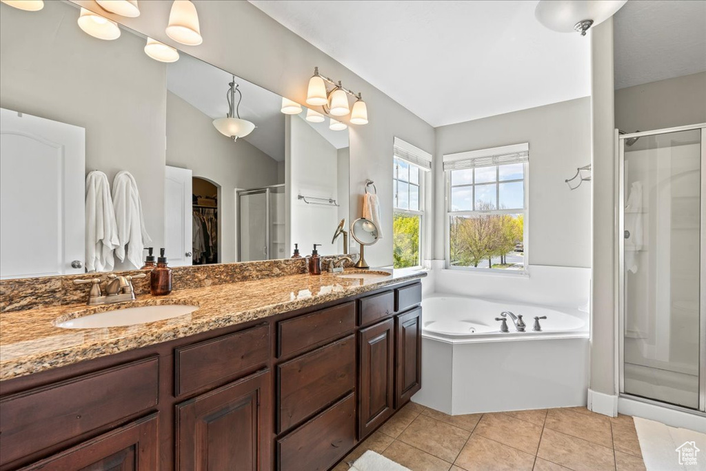 Full bath with a bath, double vanity, a shower stall, and a sink