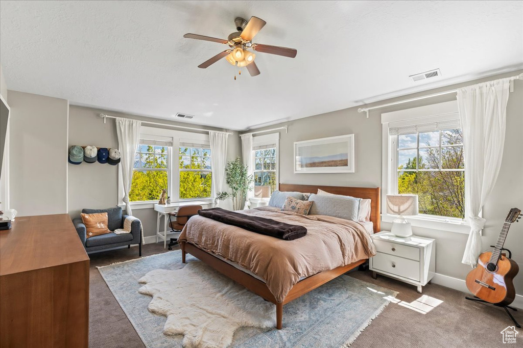 Bedroom with baseboards, visible vents, and carpet