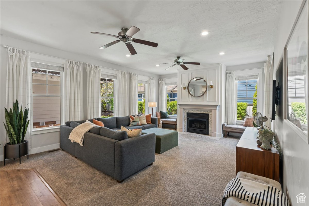 Living room with a fireplace, wood finished floors, recessed lighting, and ceiling fan