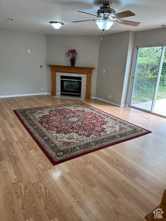 Living room featuring visible vents, wood finished floors, a textured ceiling, and ceiling fan