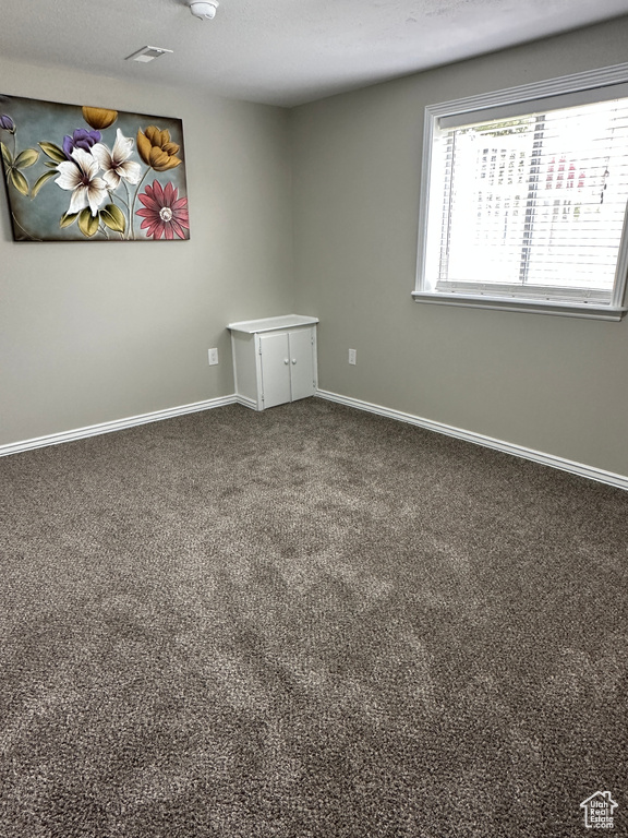 Spare room featuring baseboards and carpet flooring