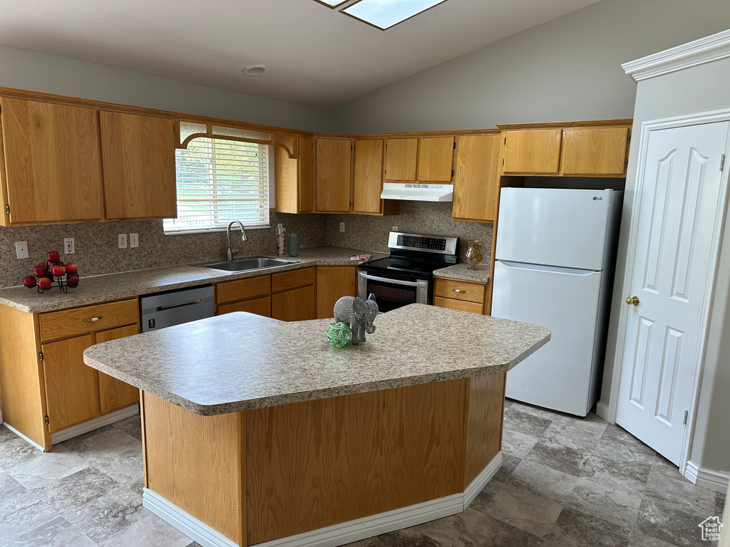 Kitchen featuring lofted ceiling, under cabinet range hood, a sink, freestanding refrigerator, and stainless steel electric range
