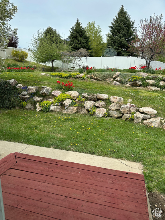 View of yard featuring fence and a deck