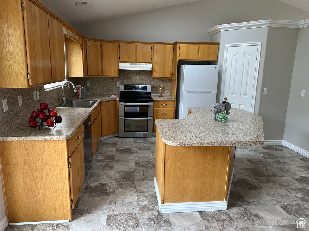 Kitchen featuring a sink, double oven range, freestanding refrigerator, stone finish flooring, and under cabinet range hood