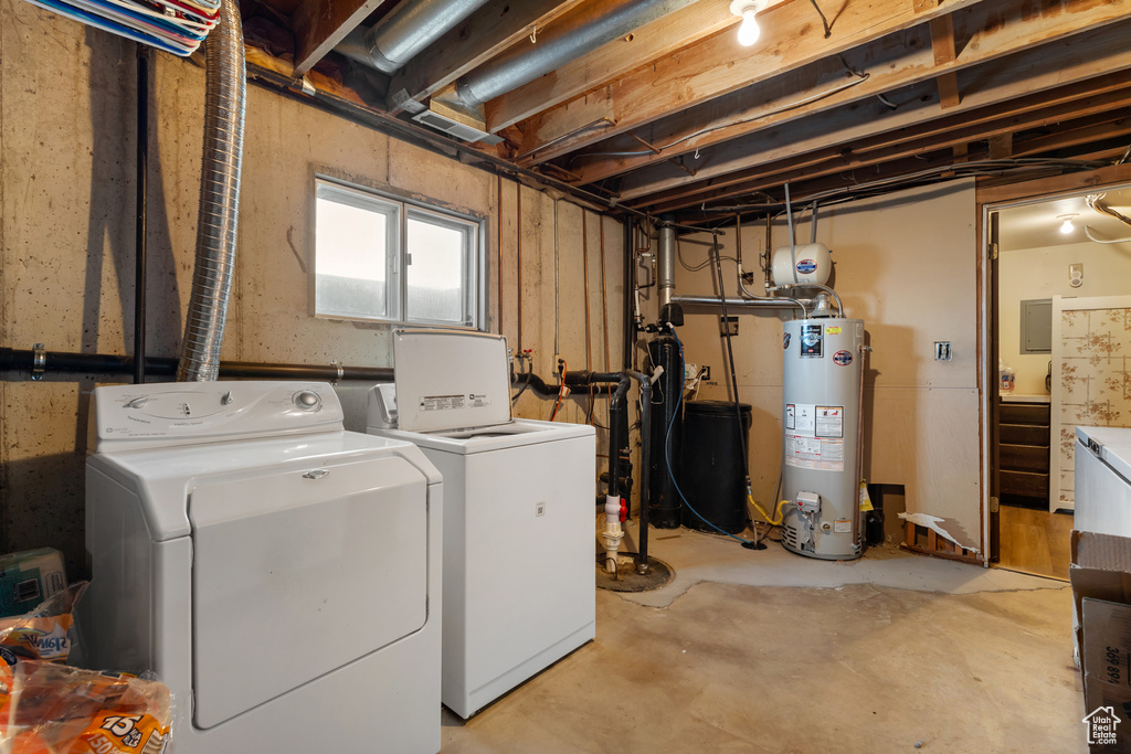 Washroom featuring water heater, washer and clothes dryer, and laundry area