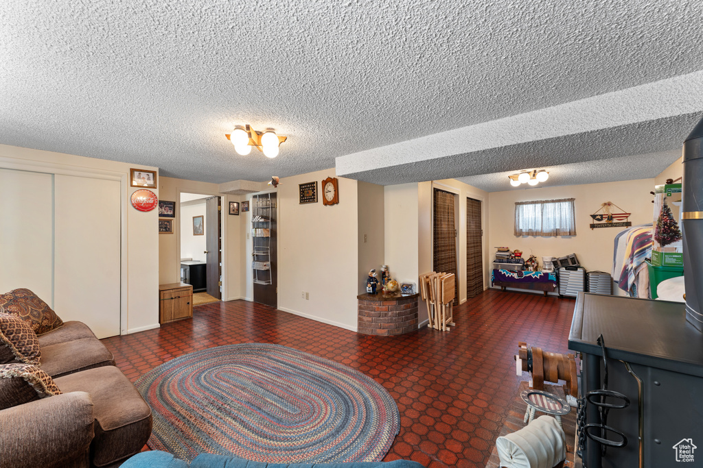 Living area featuring baseboards and a textured ceiling