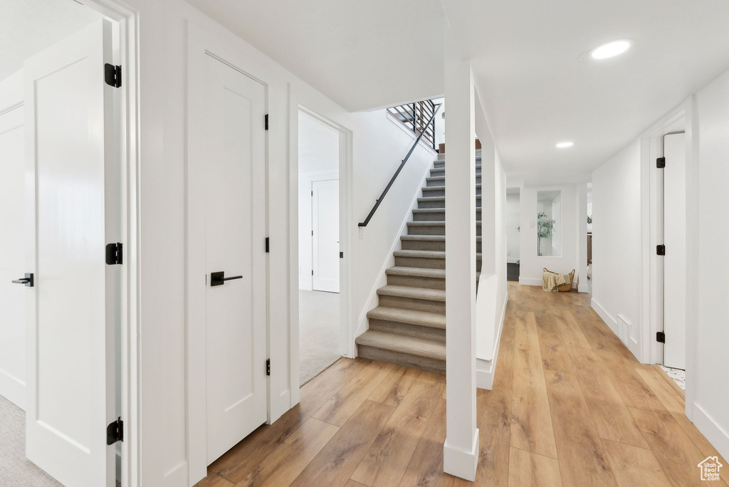 Staircase with hardwood / wood-style flooring, baseboards, and recessed lighting