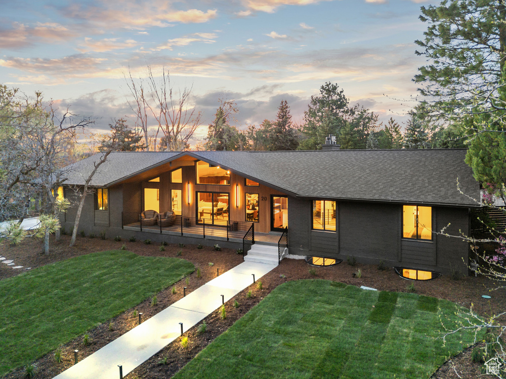 View of front of property with a shingled roof and a front yard
