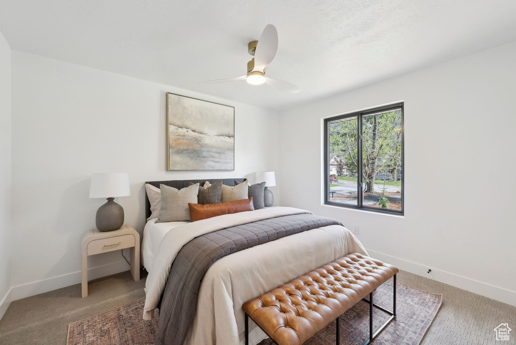 Carpeted bedroom featuring baseboards and a ceiling fan