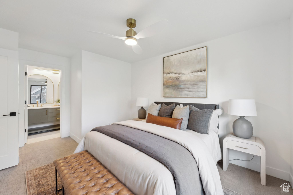 Bedroom with baseboards, light colored carpet, ceiling fan, and connected bathroom