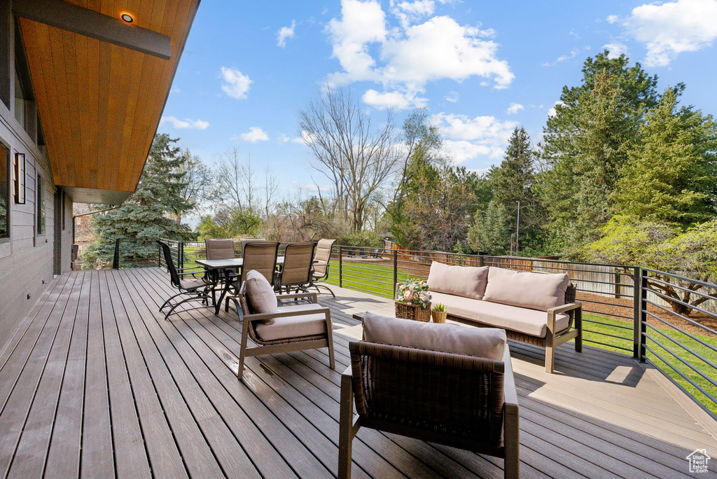 Wooden deck featuring a lawn, outdoor lounge area, and outdoor dining area