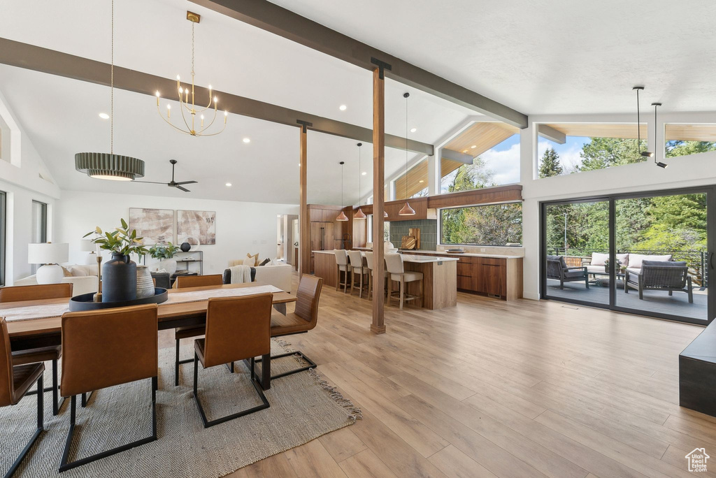 Dining space with recessed lighting, beamed ceiling, light wood-style flooring, high vaulted ceiling, and ceiling fan with notable chandelier
