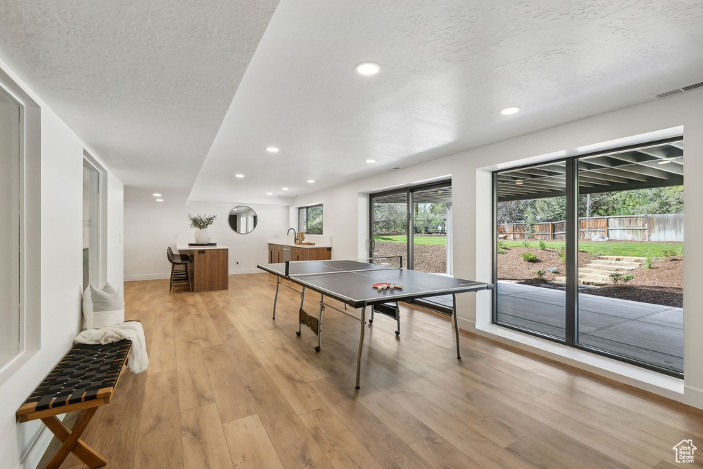 Playroom featuring recessed lighting, a textured ceiling, light wood-style flooring, and visible vents