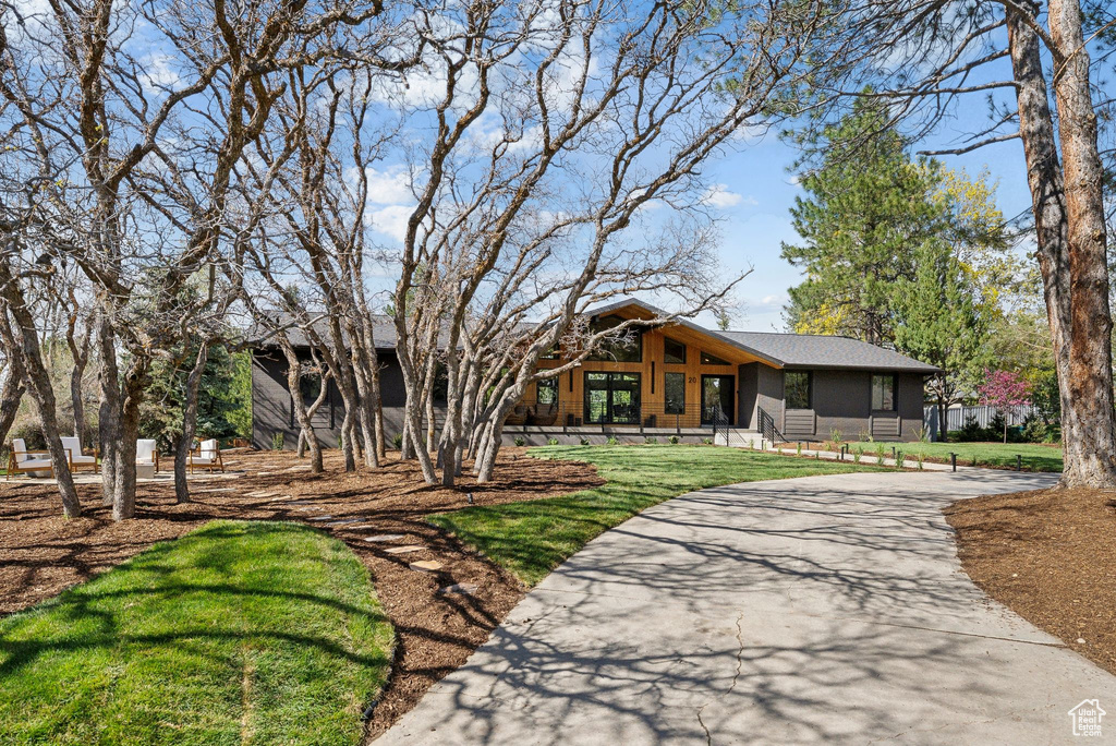 View of front of property featuring a front lawn and curved driveway