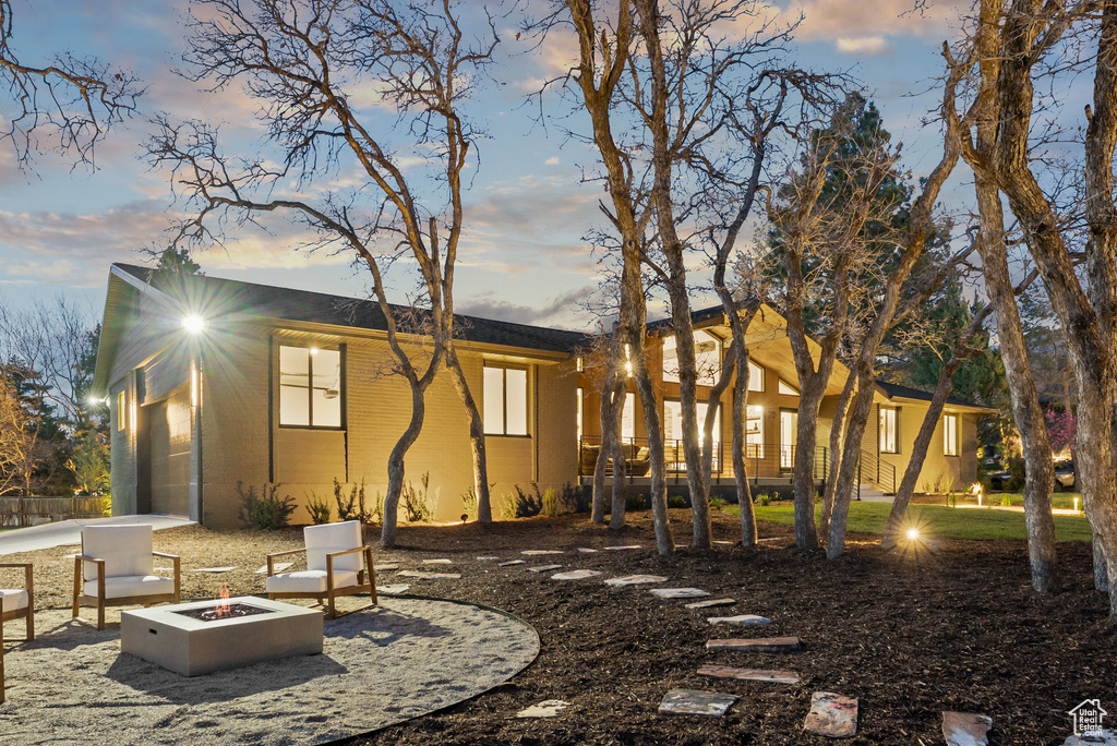 Back of house at dusk with an outdoor fire pit