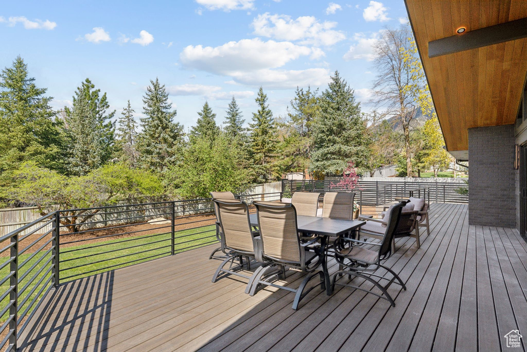 Wooden terrace featuring fence and outdoor dining space