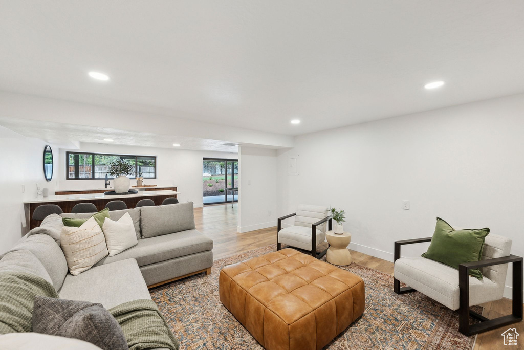 Living room featuring baseboards, light wood-type flooring, and recessed lighting