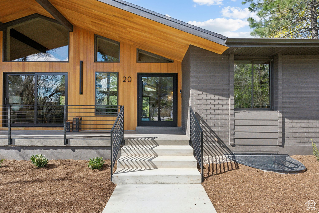 Property entrance with brick siding and a porch